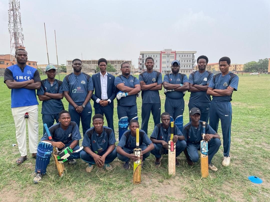 The IMCC squad lined up on the outfield in navy club kit with bats and pads