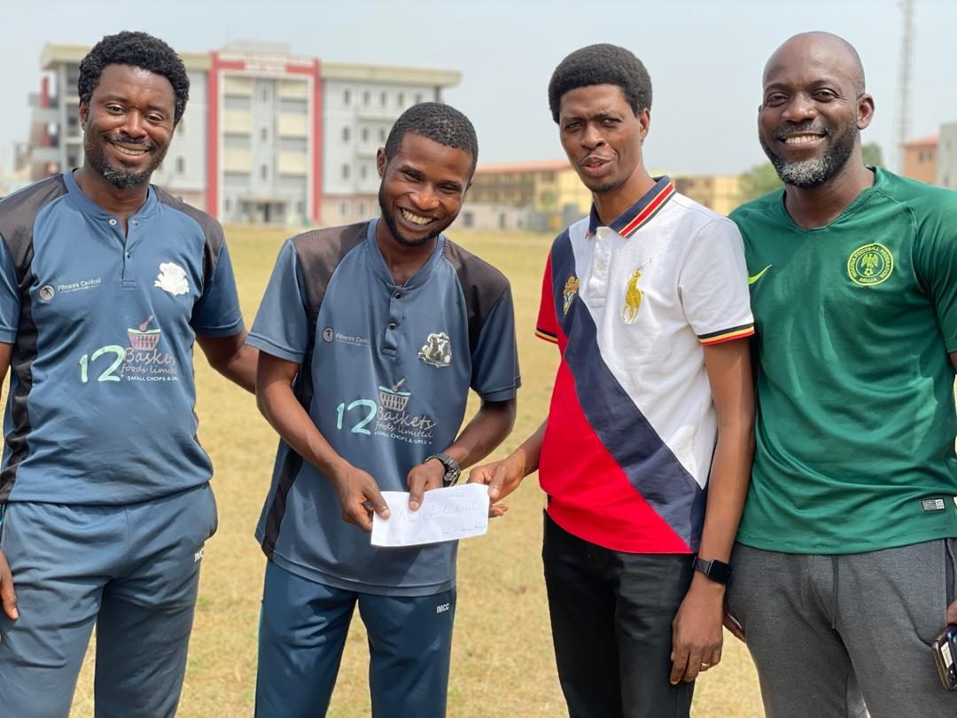 Four club members standing together holding a presentation envelope